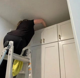 Woman in a chair cleaning a wardrobe